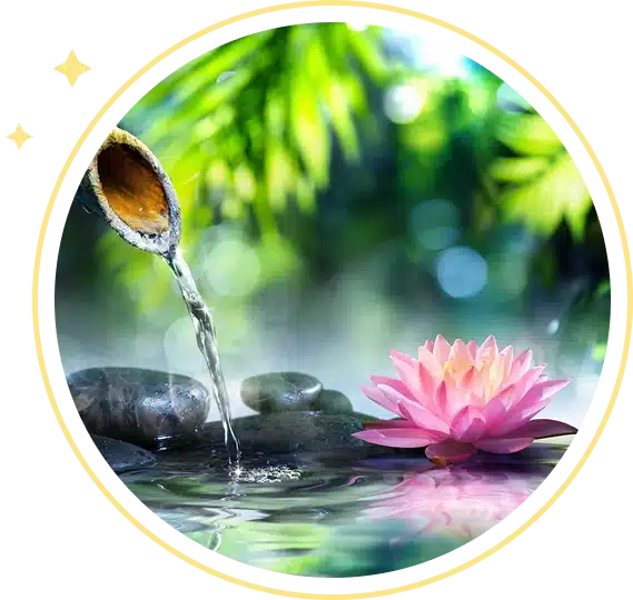 Water pouring from a bamboo spout over stones next to a pink lotus.