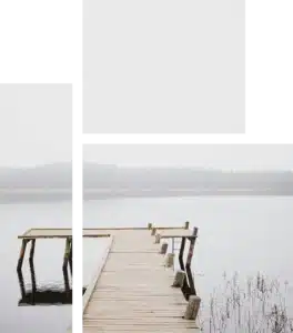 Wooden pier extending into a calm, foggy lake.