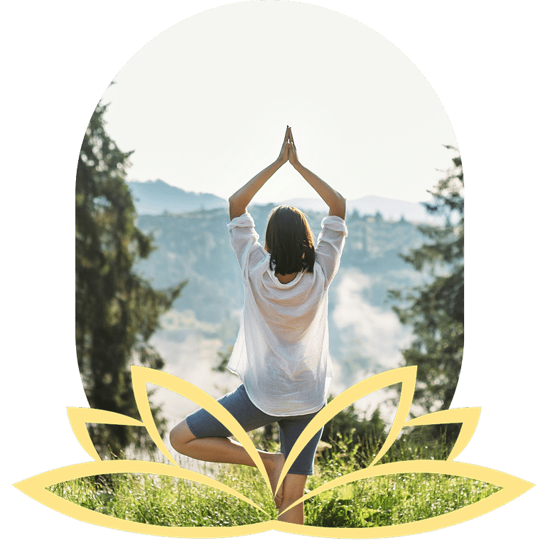 Woman in white shirt doing tree pose with misty mountains.