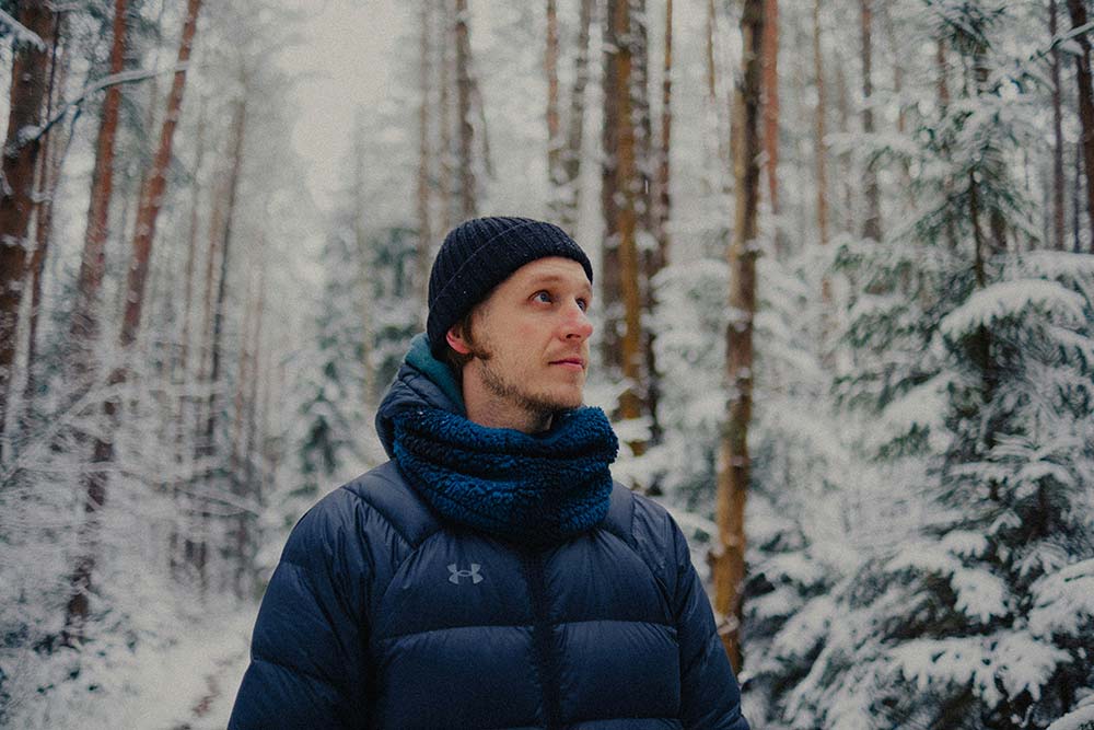 man wearing winter clothes in snowy forest