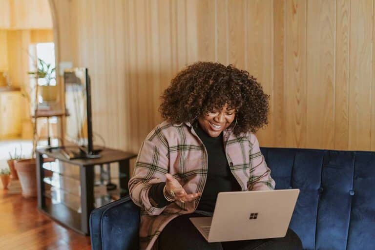 person sitting on couch holding a surface device