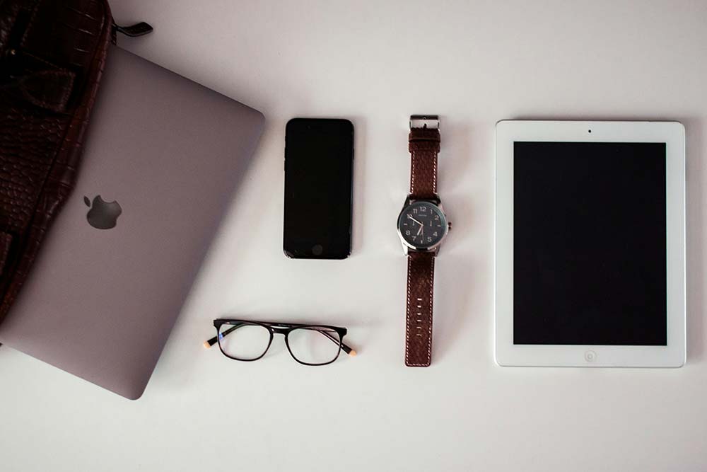 white ipad beside round silver colored analog watch
