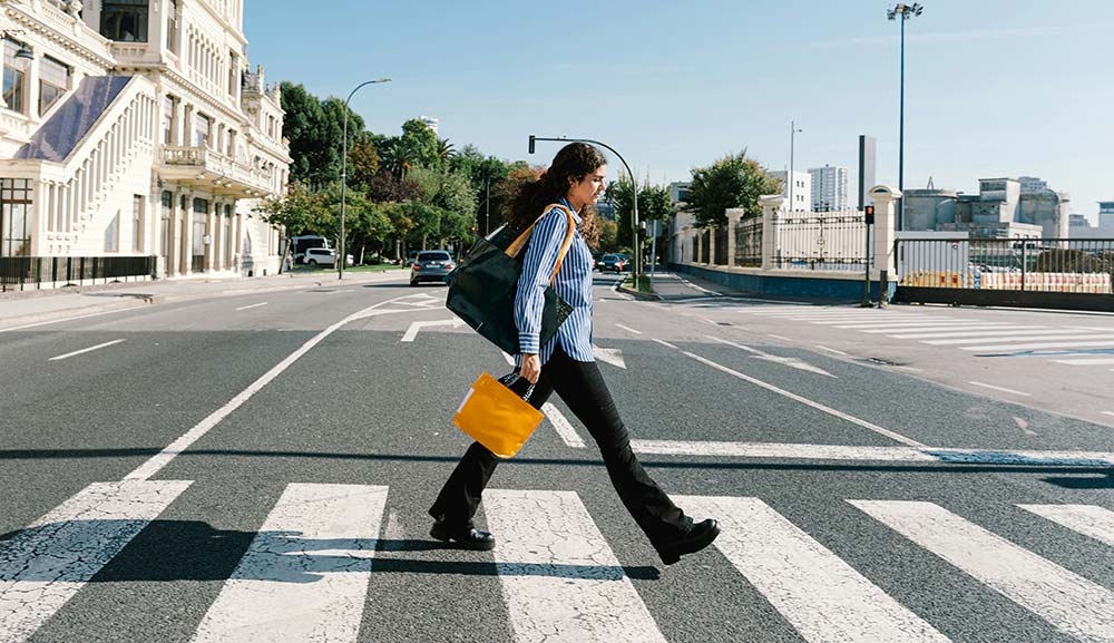 woman crossing a street on a sunny day
