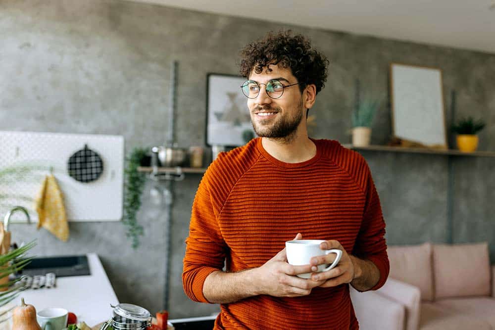 young-man-enjoying-a-cup-of-coffee-in-his-domestic-kitchen